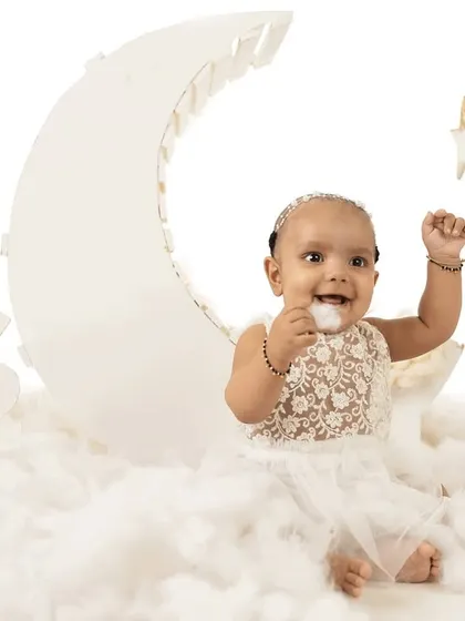 A playful moment on the moon. Sitter sessions are perfect for capturing your baby's personality as they start to interact and play.