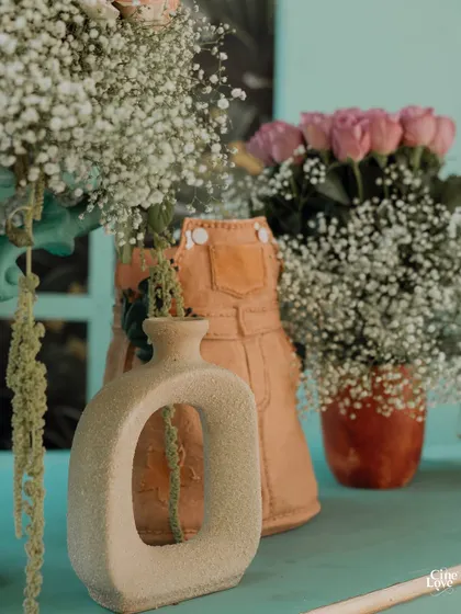 A close-up of some of the unique, modern vases used in the decor. The mix of contemporary shapes with soft, romantic flowers creates a fresh and stylish look.