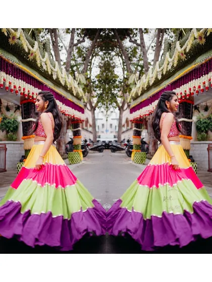 A creative shot of our bride Varsha in her multi-colored Mehendi lehenga, showing off its beautiful colors and flare.