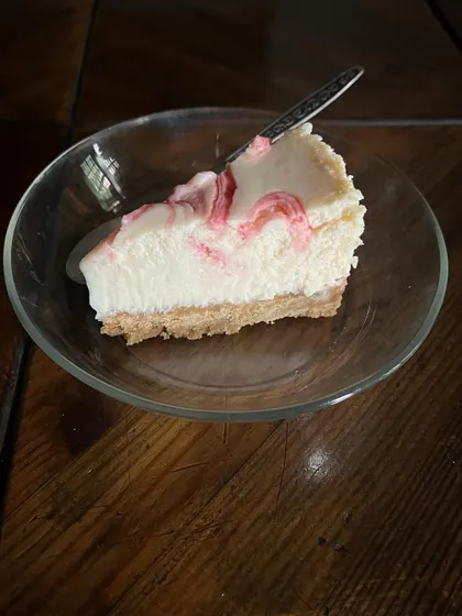 A perfect slice of my creamy, dreamy berry swirl cheesecake. You can see the beautiful swirl of homemade berry compote running through it.