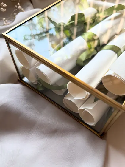 A close-up of the glass keepsake box filled with handwritten vow scrolls. This is a beautiful way to store and display the most important words you'll ever exchange.