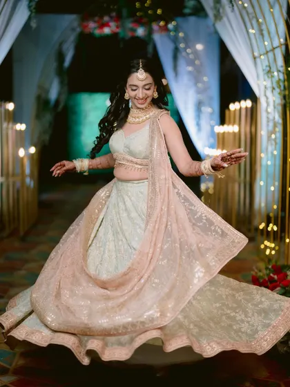 Another beautiful shot of the bride twirling, showcasing the flow and detail of her outfit.