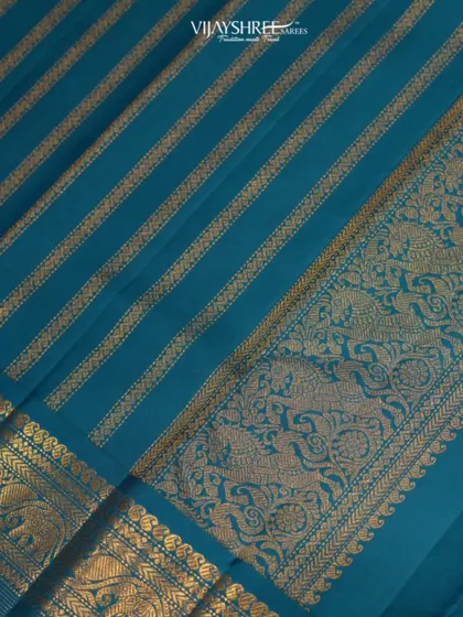 A close-up of a heritage pallu in teal blue, featuring intricate Yalli and peacock motifs woven in gold zari.