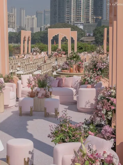 The sprawling setup of our 'Handpainted Story' wedding, showcasing different seating zones against the urban skyline of Mumbai.