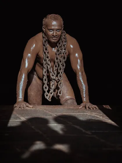 A series of dramatic, low-key portraits of a wrestler with heavy chains draped around his neck. These photos symbolize the immense strength and burden of the Pailwan's discipline.