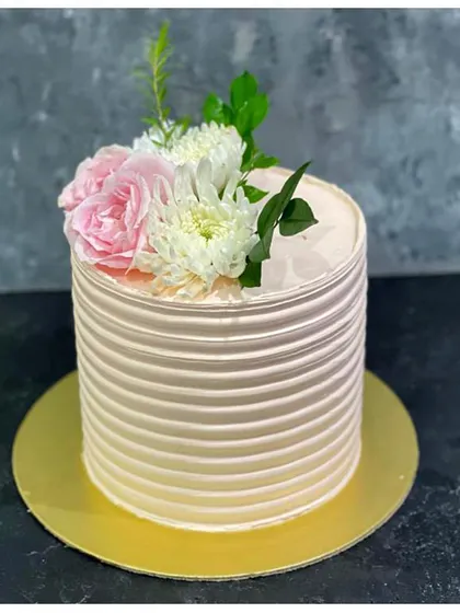 A beautiful ridged buttercream cake in a soft pink ombre, topped with fresh flowers. This design is perfect for birthdays, bridal showers, or any elegant occasion.