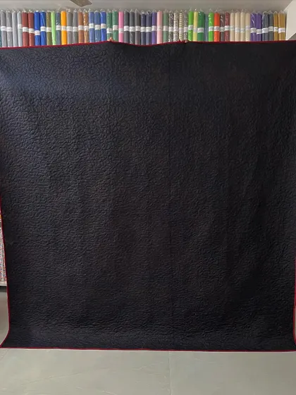 The simple black backing allows the intricate quilting pattern to stand out.