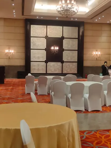 Another angle of the conference hall setup. Notice the clean chair covers and organized table layouts, small details that contribute to a professional atmosphere.