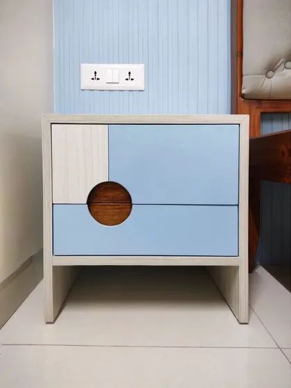 A close-up of the modern bedside table with its unique circular handle, showcasing the blend of different materials and colors.