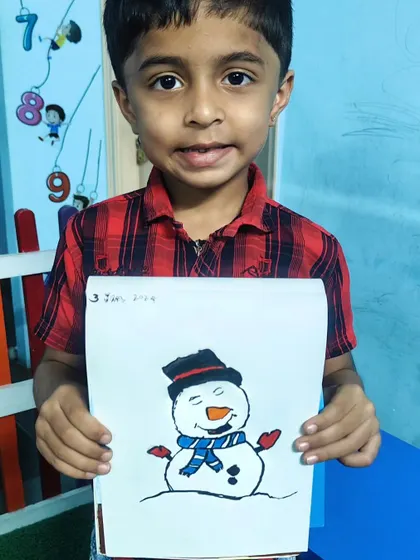 This student is proud to show off the friendly snowman he drew and colored in our class.