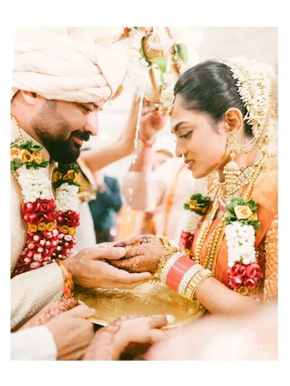 A tender moment during a traditional Indian wedding ceremony. The groom's gentle touch and the bride's serene expression are captured in this intimate and emotional photograph.