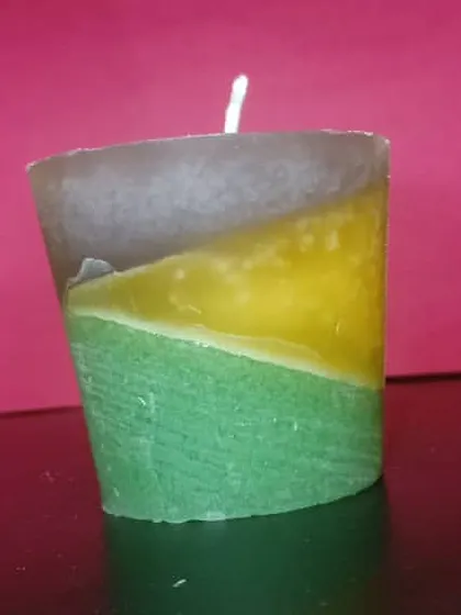 This layered candle features a unique diagonal design with yellow, green, and brown wax. Each one is poured by hand to create this artistic effect.
