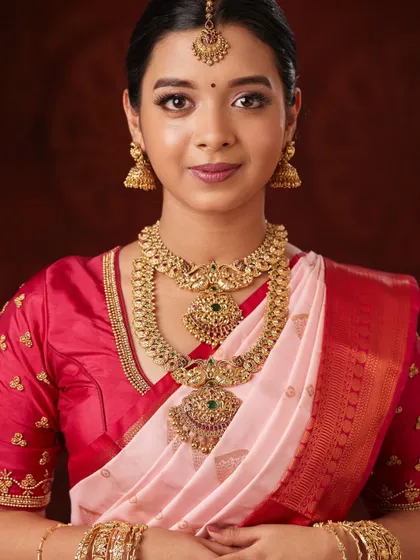 A portrait shot that beautifully captures the details of the choker, haaram, and jhumkas.
