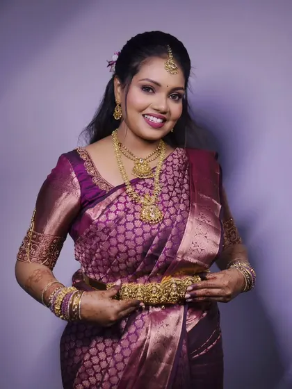 An elegant portrait of a woman in a beautiful purple silk saree, taken during her engagement ceremony.