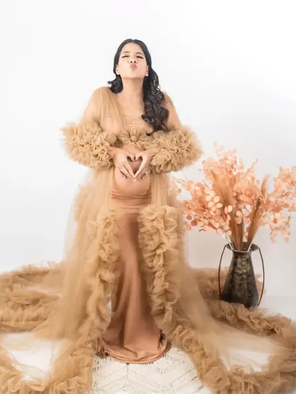 A playful and loving pose in one of my most popular gowns. This mom-to-be is making a heart shape over her bump, a sweet gesture that we captured to make the photo even more personal.