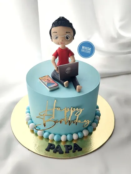 A simple and sweet cake for dad. This design features a handcrafted figurine of a dad working on his laptop, a common sight in many homes.