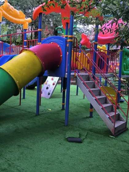 The colorful play structure looks even better against the vibrant green of the new artificial grass floor at the Nainital Eco Cave Garden.