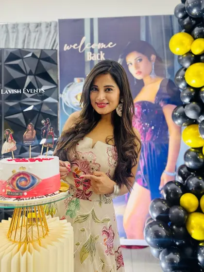 A welcome back party for BBK star Anusha Rai, featuring a custom banner, a 3D geometric wall, and a black and yellow color scheme.