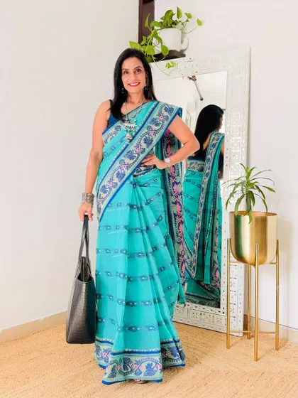 This turquoise blue printed Tant saree is so vibrant and pretty. It's a great workwear option that is both comfortable and stylish.