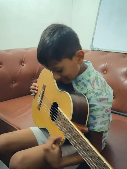 A young boy hugging his guitar. We love seeing our students form a deep, personal connection with their instruments.
