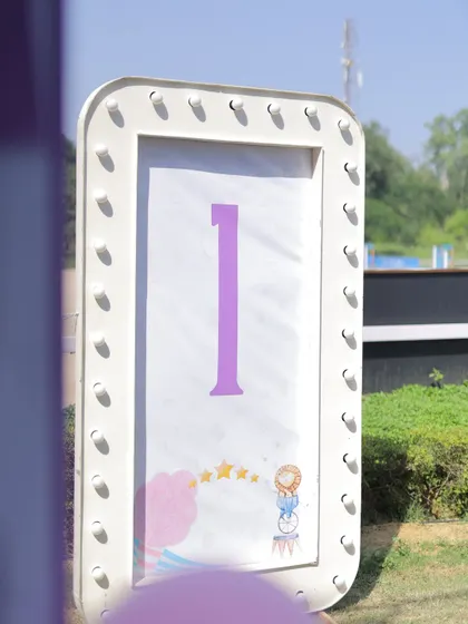 A light-up marquee sign displaying the number '1' for a first birthday carnival. The simple, elegant design with a small circus graphic is perfect for capturing milestone photos.