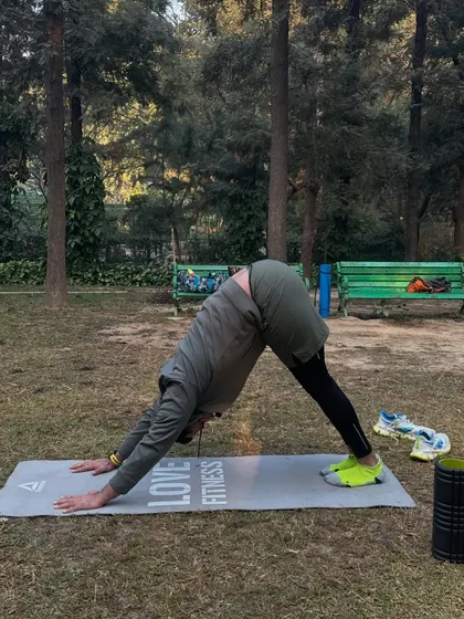 Moving into Downward-Facing Dog (Adho Mukha Svanasana) to stretch the entire back of the body, from the shoulders to the hamstrings.
