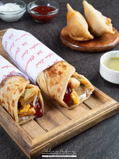 These Kathi Rolls are shot to look like a delicious and convenient meal. The branded paper and simple wooden tray styling make it ideal for a quick-service restaurant or delivery brand.