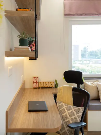 A dedicated study desk with open shelving makes this multi-functional room complete. The design ensures that even with a compact layout, there is a comfortable and well-lit space for work or study.