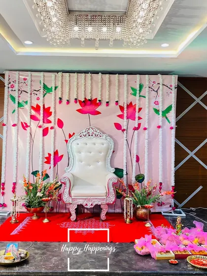 For a traditional Seemantham, we created this elegant stage with an ornate white throne chair for the mother-to-be. The backdrop, adorned with lotus and hummingbird motifs and framed by fresh tuberose garlands, sets a serene and sacred tone for the ceremony.