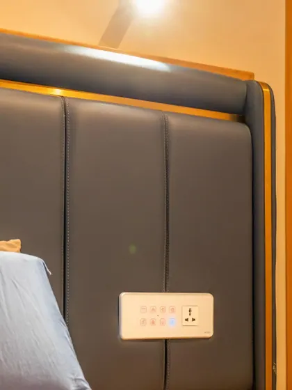 A smart panel integrated into a sleek, modern headboard, offering convenient control without cluttering the bedside table.