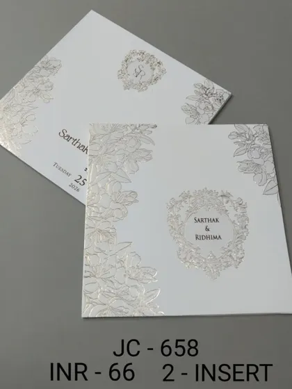 A simple white invitation with a silver foil floral wreath for the monogram. The design is clean, fresh, and perfect for a minimalist wedding aesthetic.