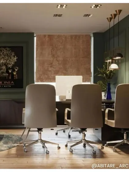 A view of the Armonia office, where we used a deep green wall color and contemporary furniture. The space is designed to be both professional and inspiring, with artwork and modern lighting fixtures adding character.