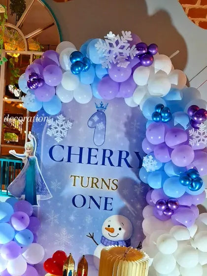 A closer look at the 'Frozen' themed backdrop, showing the character details and the snowflake balloon accents.