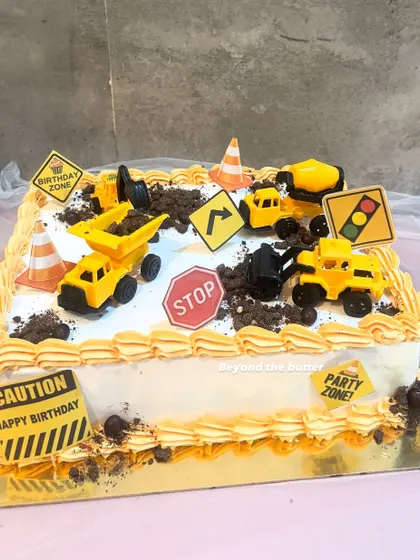 A larger, rectangular construction cake perfect for a big birthday party. This "party zone" is filled with edible dirt, caution signs, and a whole crew of construction vehicles.