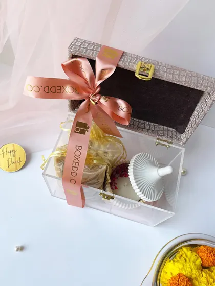 We believe Diwali gifts should be a surprise. This unique acrylic and leather-finish box contains gourmet treats and a decorative candle holder, offering a refreshing change from predictable mithai boxes.