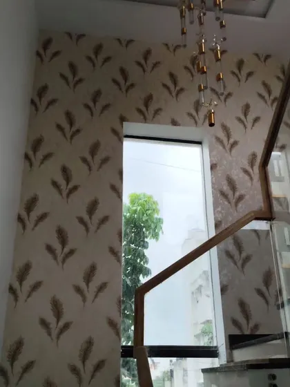 A tall staircase wall featuring a feather-patterned wallpaper. The vertical design element adds height and elegance to the space.