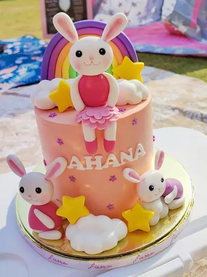 A picture-perfect picnic for a little one's birthday. This adorable bunny-themed cake, with its fondant rainbow and stars, was the perfect centerpiece for this outdoor celebration.