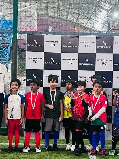 Young footballers standing with their coaches and officials after receiving their awards.