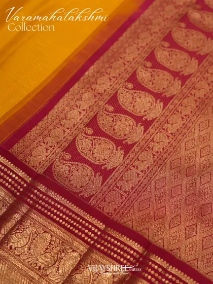 The pallu of the red and yellow saree, featuring large paisley motifs in gold zari.
