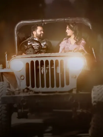 A close-up shot of a couple in our vintage jeep at night. The warm glow of the headlights creates an intimate and cinematic feel.