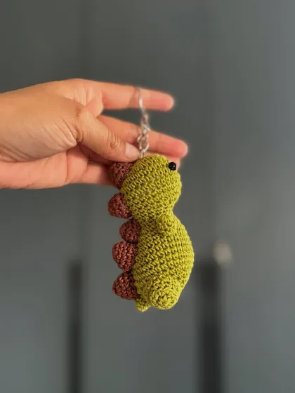 A tiny dinosaur keychain to guard your keys. This amigurumi dino is a fun and quirky accessory for all ages.