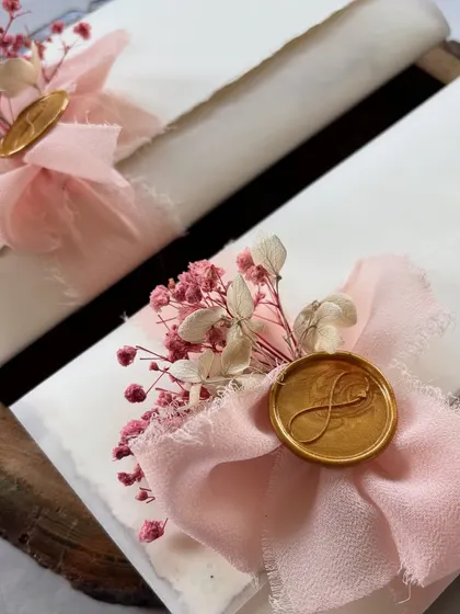 Flat scrolls are stealing my heart. These handwritten letters feature a pastel theme with soft pink silk ribbons, a gold initial wax seal, and delicate dried flowers, making them perfect for a bridesmaid gift.