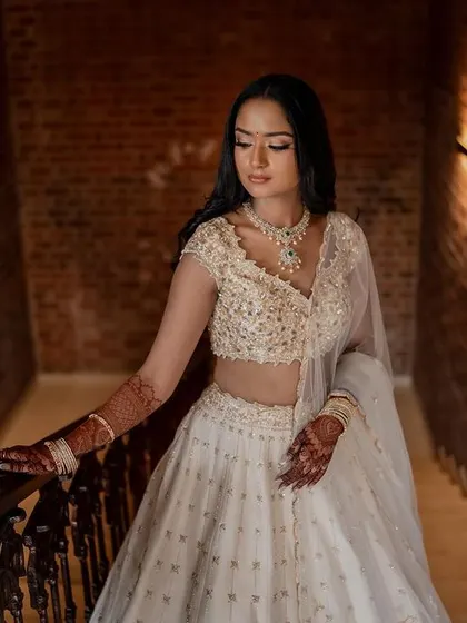 A stunning bride in a white lehenga, exuding grace and elegance. We use creative framing and lighting to capture a variety of beautiful portraits.