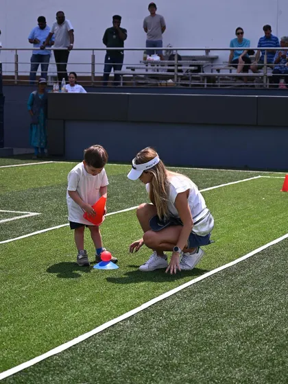 A mother helps her child with a cone-stacking game at the sports meet.