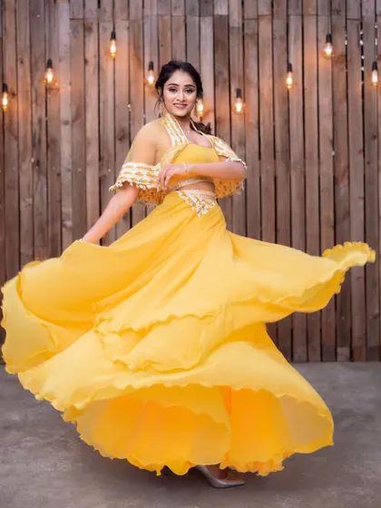 The model twirling in the yellow lehenga, showing the incredible flow and multi-layered skirt.
