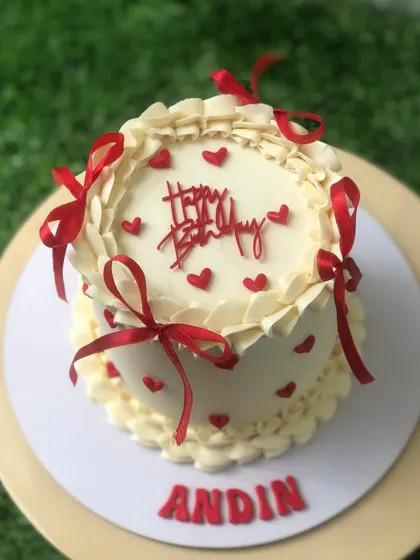 A top-down view of the vintage cake with red ribbons.
