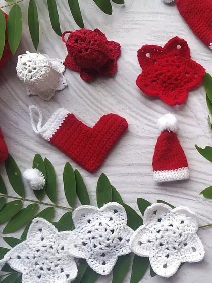 Our full range of red and white crochet Christmas ornaments laid out. You can see the different shapes we offer, from stars and bells to mini Santa hats and stockings, to create a diverse and festive tree.