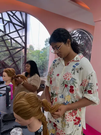 Another shot of students practicing intricate braiding and styling on mannequins.