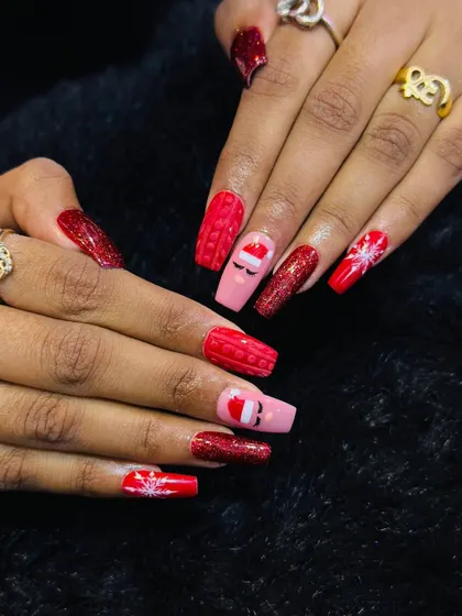 Getting into the festive spirit with this Christmas-themed nail art. This set features red glitter, hand-painted snowflakes, a cute Santa hat, and even a 3D sweater-knit texture.