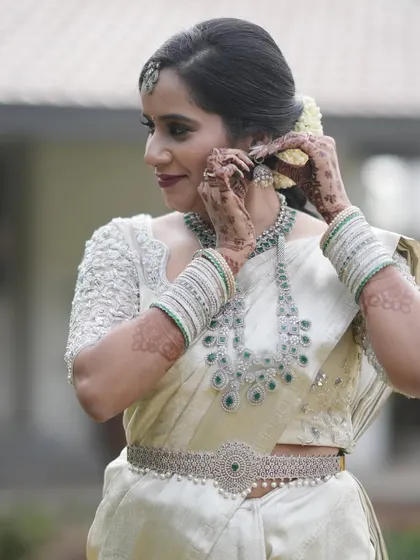 Getting ready for the big moment, the bride adjusts her earrings.